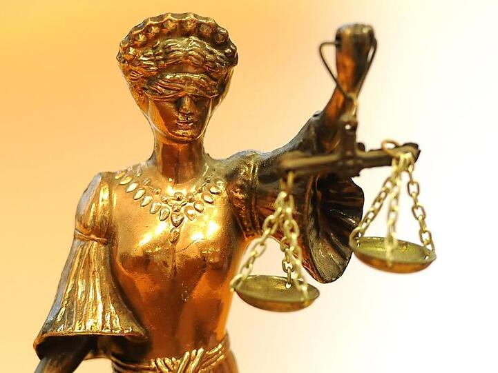 Eine goldfarbene Justitia-Figur hält eine Waage. Foto: Britta Pedersen/Archiv