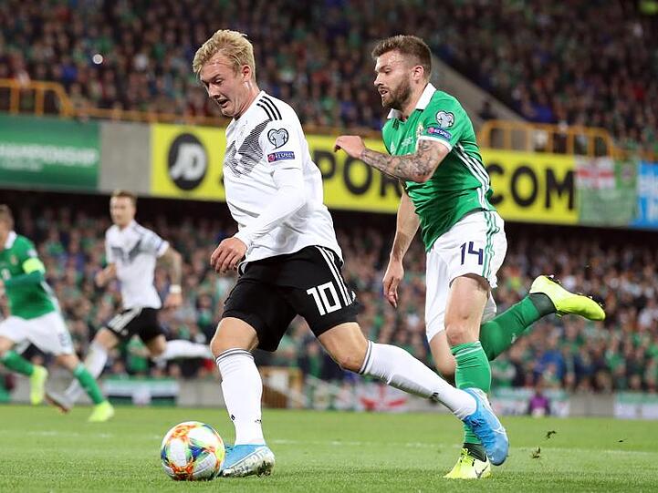 Julian Brandt (l) kann sich mit dem Ball gegen Stuart Dallas aus Nordirland behaupten.