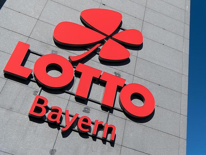 Das Logo und der Schriftzug von "Lotto Bayern" sind an dem Firmengebäude der Lottozentrale zu sehen. Foto: Sven Hoppe/Archivbild