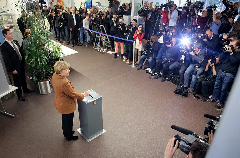 Bundeskanzlerin Angela Merkel (CDU) wirft am 22.09.2013 in Berlin ihren Stimmzettel zur Bundestagswahl 2013 in die Wahlurne.