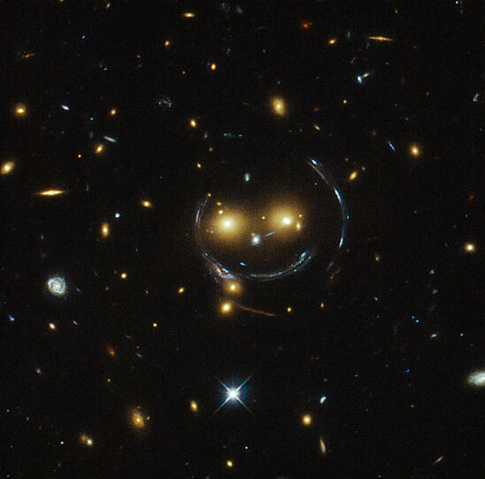 Der Galaxienhaufen SDSS J1038+4849 scheint den Betrachter anzulächeln.
