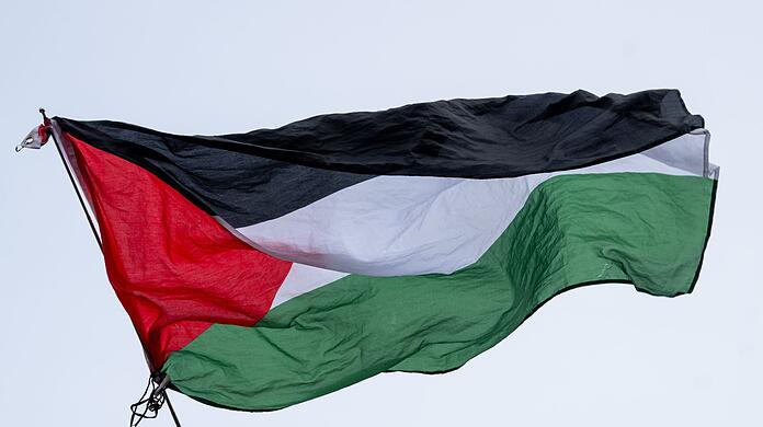 Die Flagge von Palästina wird bei einer propalästinensischen Kundgebung geschwenkt. 
Bei derartigen Kundgebungen kam es vor allem in den ersten Wochen nach dem Massaker immer wieder zu Zusammenstößen mit der Polizei.