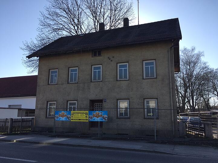 Weniger schmuck sieht das Haus von der Straße aus, da grenzt es (hier mit einem Bauzaun) direkt an den schmalen Gehweg. Bis 1938 war es ein Verwaltungsgebäude, danach eine Stadtbücherei. 1951 zogen schließlich Mieter ein &ndash; bis 2001 der letzte ausgezogen ist.