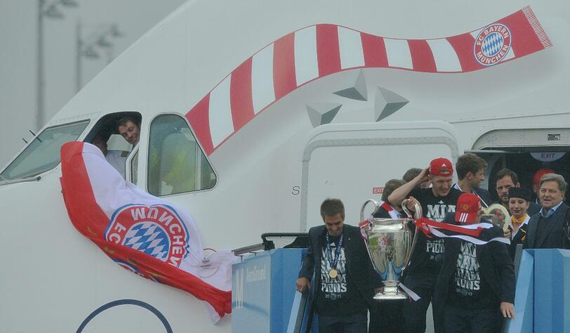 Herzlich Willkommen dahoam! Die Bayern-Spieler kommen mit dem Pott zurück nach München. Die Bilder.