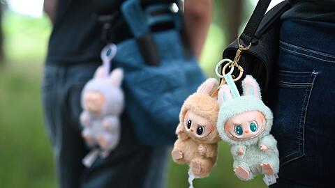 Zwei Frauen tragen Labubu-Anhänger an ihren Umhängetaschen. (Archivbild)