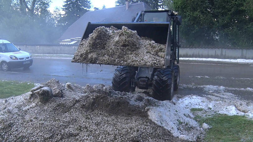 Eine Radladerschaufel voll mit Hagel.