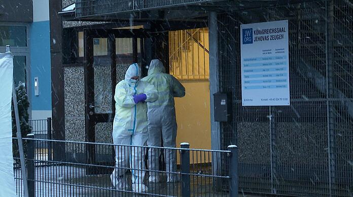 Ermittler stehen am Morgen vor dem Gebäude der Zeugen Jehovas in Hamburg, in dem mehrere Menschen getötet wurden.