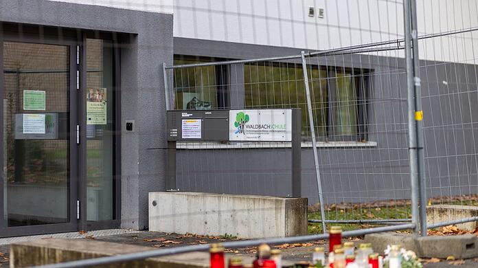Blumen und Kerzen liegen vor der Waldbachschule in Offenburg.