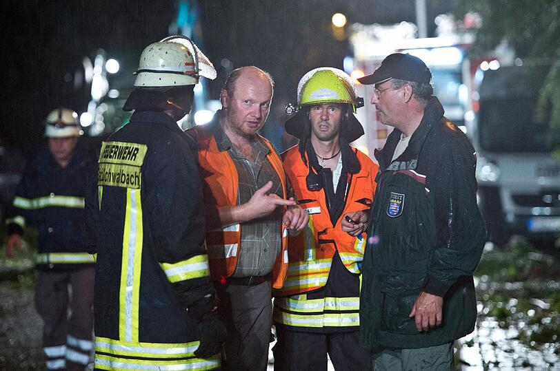 Feuerwehrleute und Polizisten besprechen sich bei den Aufräumarbeiten.