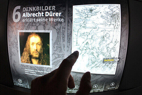 Ein digitaler Albrecht Dürer erklärt in der Ausstellung auf einem Touchscreen eines seiner Werke.