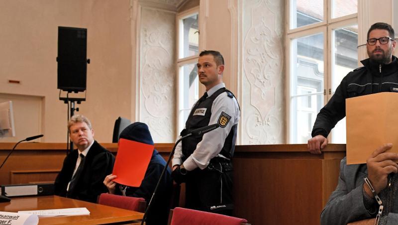 Der Vater (r) auf der Anklagebank mit Aktendeckel vor dem Gesicht, links einer der angeklagten Söhne. Foto: Stefan Puchner/dpa/Archivbild Der Vater (r) auf der Anklagebank mit Aktendeckel vor dem Gesicht, links einer der angeklagten Söhne. Foto: Stefan Puchner/dpa/Archivbild