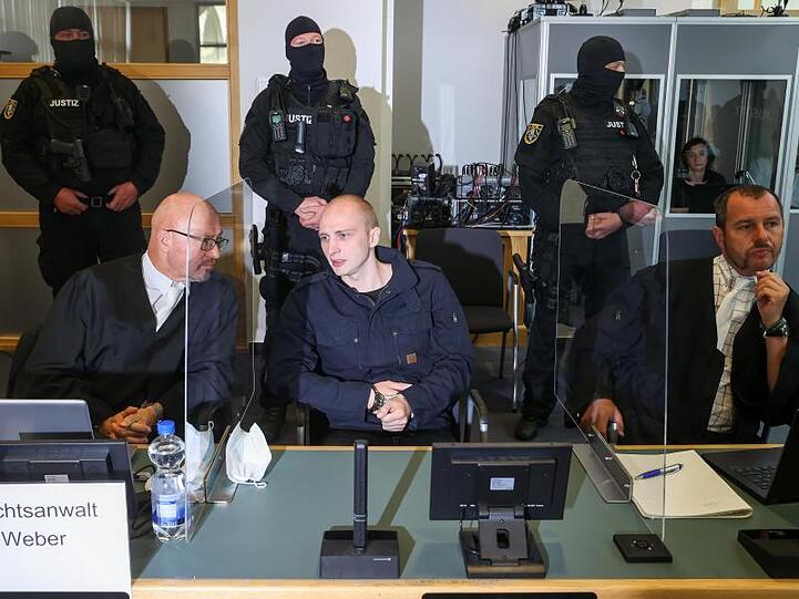 Der Angeklagte Stephan Balliet sitzt zwischen seinen Anwälten im Verhandlungssaal im Magdeburger Landgericht.