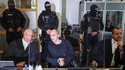 Der Angeklagte Stephan Balliet sitzt zwischen seinen Anwälten im Verhandlungssaal im Magdeburger Landgericht.