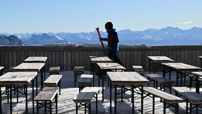 Ein Skifahrer geht über die leere Terasse am Zugspitzplatt.