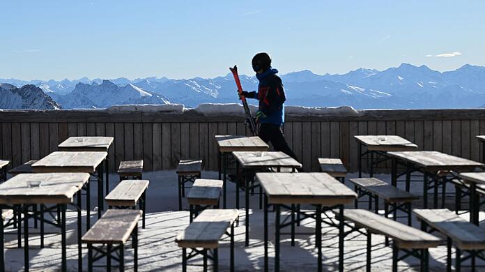 Ein Skifahrer geht über die leere Terasse am Zugspitzplatt.