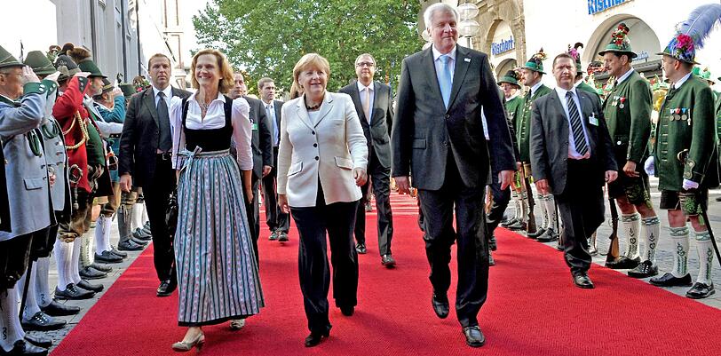 Ministerpräsident Horst Seehofer empfängt Kanzlerin Merkel vor der Kirche St. Michael, wo mit einem ökumenischen Gottestdienst die heutigen Feierlichkeiten zum Tag der Deutschen Einheit begannen. Ganz im Zeichen der Wiesn: Präsidentengattin Karin Seehofer (lonks).