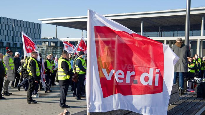 Mitarbeiter des Sicherheitspersonals am Flughafen BER stehen bei einem Warnstreik vor dem Terminal.