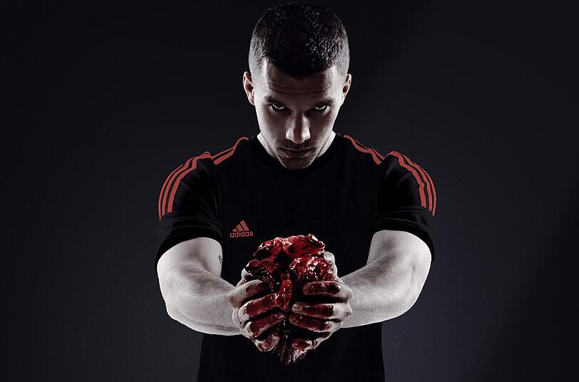 Lukas Podolski posiert mit einem blutigen Kuhherz für eine Werbeaktion seines Sponsors Adidas.