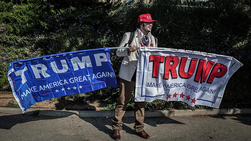 Jerusalem: Ein Anhänger von US Präsident Trump steht mit Fahnen "Trump: Make America great again" an der Straße vor der Eröffnung der neuen US Botschaft in Jerusalem.