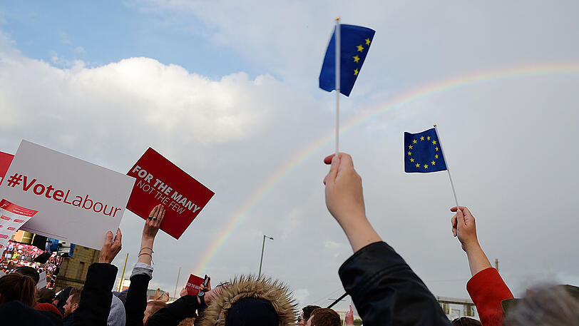 Anhänger Corbyns stehen in Birmingham auf einer Wahlkampfveranstaltung unter einem Regenbogen.