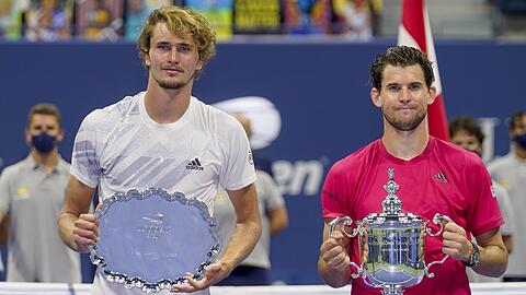 Dominic Thiem (r) und Alexander Zverev halten nach dem dramatischen US-Open-Finale jeweils ihre Trophäe in den Händen.