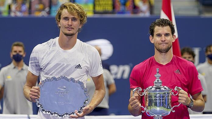 Dominic Thiem (r) und Alexander Zverev halten nach dem dramatischen US-Open-Finale jeweils ihre Trophäe in den Händen.