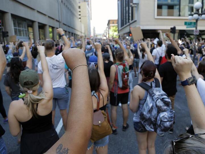 Demonstranten protestieren in der Nähe der Stadt Minneapolis und erheben solidarisch ihre Faust. Nach dem Tod des Afroamerikaners George Floyd bei einer brutalen Festnahme hat die Stadt Minneapolis erste Reformen ihrer Polizei auf den Weg gebracht.