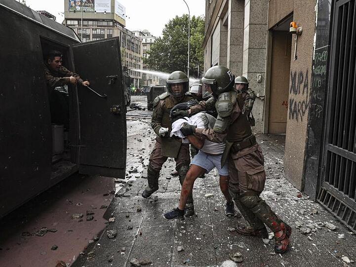 Polizisten verhaften einen Demonstranten: Die gewalttätigen Ausschreitungen in Chile nehmen kein Ende.