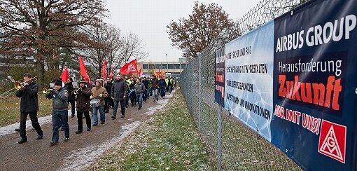 Mit einer Blaskapelle treffen Beschäftigte von Cassidian, einer Tochtergesellschaft des Luft- und Raumfahrtkonzerns EADS, am 28.11.2013 vor dem Werk in Manching (Bayern) zu einer Protestkundgebung gegen einen geplanten Stellenabbau ein.