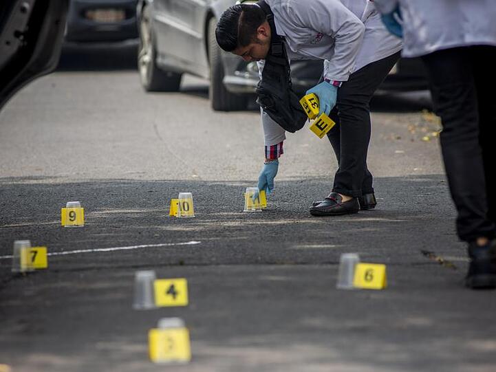Ein forensischer Experte sammelt Beweise nach dem Tod von zwei Menschen nach einem Streit zwischen zwei kriminellen Organisationen im Norden von Mexiko-Stadt.
