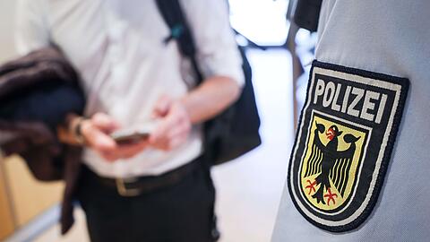 Ein Beamter der Bundespolizei kontrolliert einen Mann.