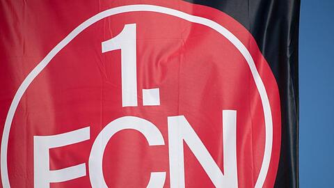 Eine Vereinsfahnen mit dem Logo des 1. FC Nürnberg. Foto: Daniel Karmann/dpa/Archivbild