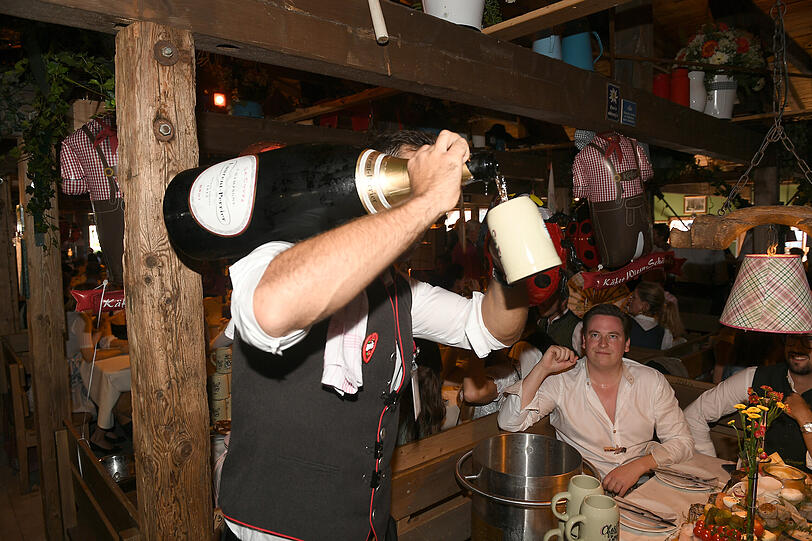 Ein gewohntes Bild auf der Wiesn: Ein Kellner schenkt einem Gast Champagner im Käferzelt aus. Ein gewohntes Bild auf der Wiesn: Ein Kellner schenkt einem Gast Champagner im Käferzelt aus.