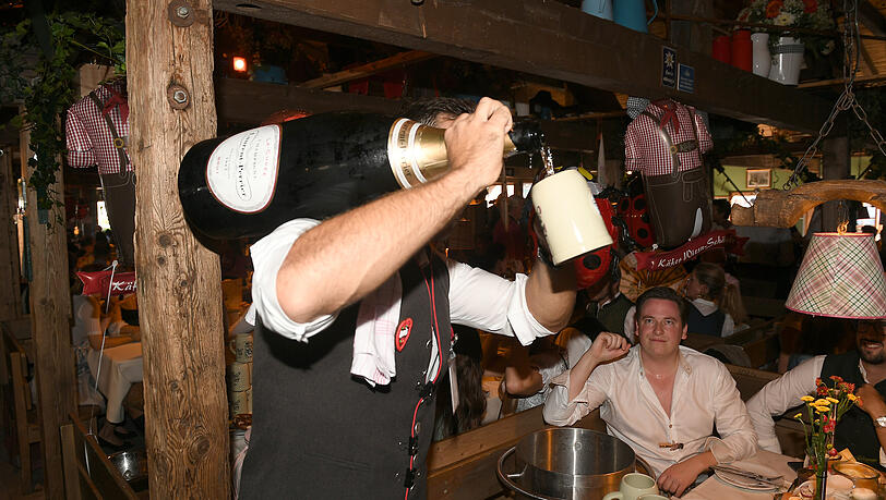 Ein gewohntes Bild auf der Wiesn: Ein Kellner schenkt einem Gast Champagner im Käferzelt aus. Ein gewohntes Bild auf der Wiesn: Ein Kellner schenkt einem Gast Champagner im Käferzelt aus.