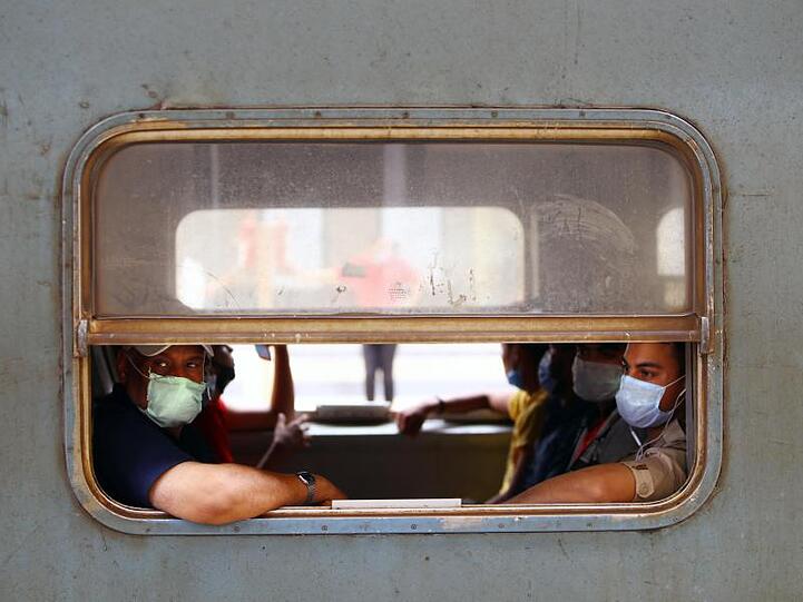 Menschen mit Gesichtsmasken sitzen in einem Zug in Kairo.
