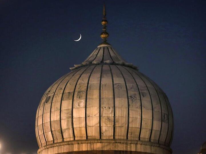 Die dünne Sichel des Mondes steht über der Jama Moschee in Neu Delhi.