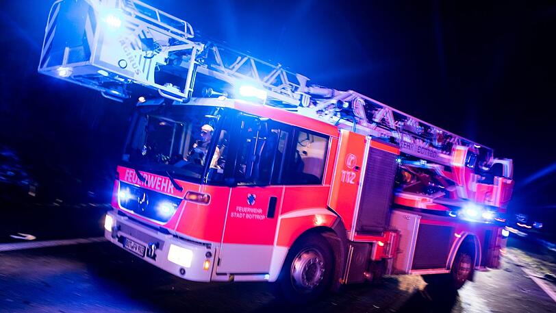 Ein Drehleiterwagen der Feuerwehr fährt mit Blaulicht zu einem Einsatz. (Symbolbild)