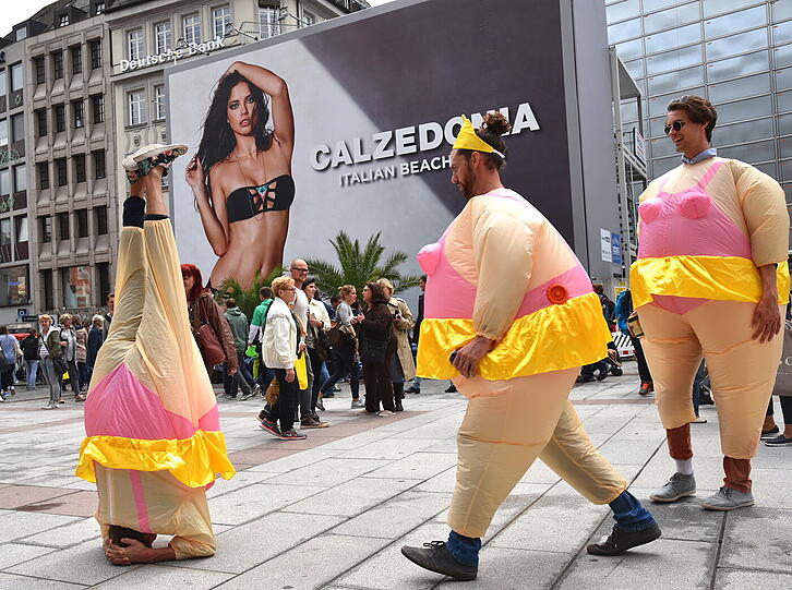 Am Ende werden sie zum Fotomotiv: Passanten scharen sich um die Junggesellen, die sich vor der Calzedonia-Werbung am Marienplatz prächtig amüsieren.