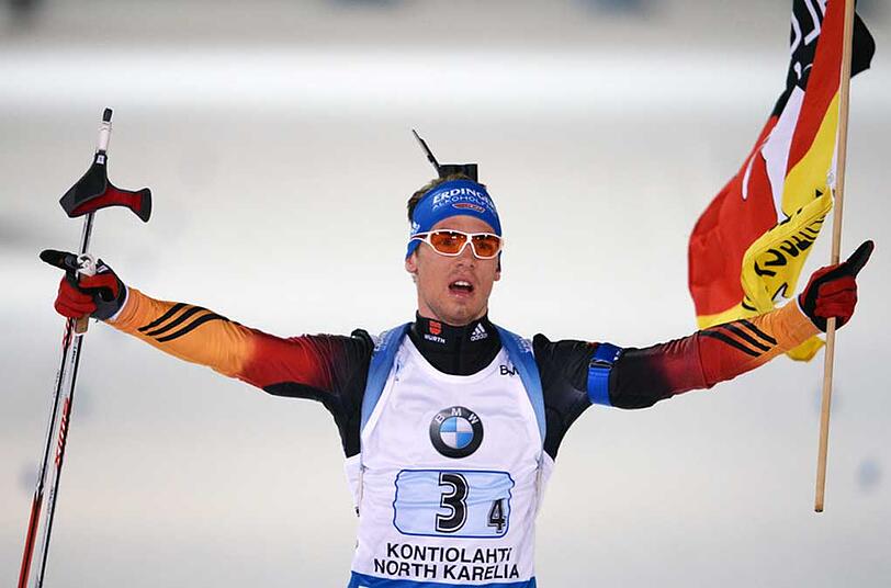 Simon Schempp, der Schlussläufer des Biathlon-Quartetts fährt mit der Deutschland-Fahne ins Ziel. Der WM-Titel ist perfekt.