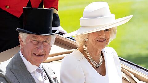 König Charles III. und seine Frau, Königin Camilla, fahren traditionell mit der offenen Landauer-Kutsche von Schloss Windsor nach Ascot zur Rennbahn.