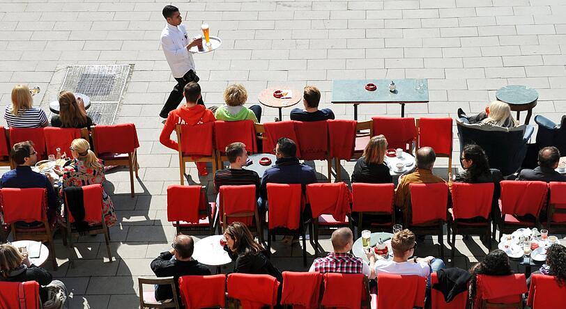 Besucher eines Straßencafes sitzen am Donnerstag (01.03.2012) in der Sonne in München.