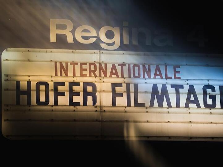 Auf einer Tafel ist die Aufschrift "Internationale Hofer Filmtage" zu lesen (Langzeitbelichtung). Foto: Nicolas Armer/dpa/Archivbild