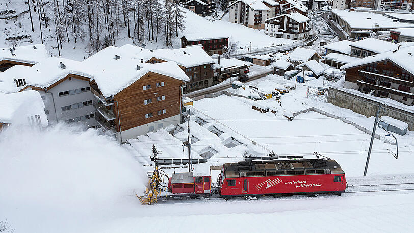 Eine an eine Lok gekoppelte Schneefräse befreit in Zermatt die Zugschienen vom Schnee. Aufgrund des schweren Schneefalls und der Regenschauer war Zermatt nur über den Luftweg erreichbar. Nach stundenlangem Einsatz der Räumfahrzeuge wurde die Bahnstrecke nach Zermatt von Schneemassen befreit: Am frühen Abend fuhren nach zwei Tagen wieder die ersten Züge in das autofreie Dorf.