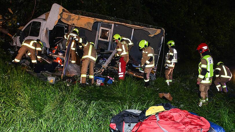 Die Einsatzkräfte vor dem völlig zerstörten Campingwagen.