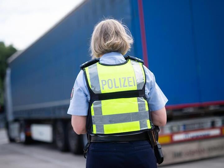 Eine Polizistin steht an einem Lastwagen. Foto: Jonas Güttler/dpa/Symbolbild