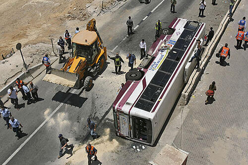 Der umgestürzte Bus, daneben steht der Bulldozer
