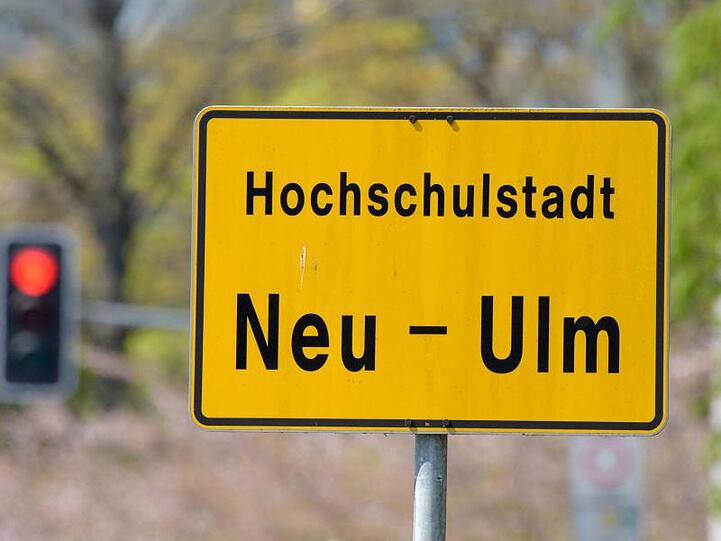 Hinter dem Ortsschild Neu-Ulm steht eine rote Ampel. Foto: Stefan Puchner/Archivbild