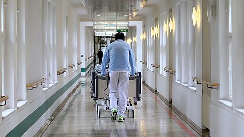 Alltag im städtischen Krankenhaus Schwabing: Ein Krankenpfleger bringt einen Patienten zu einer Untersuchung.