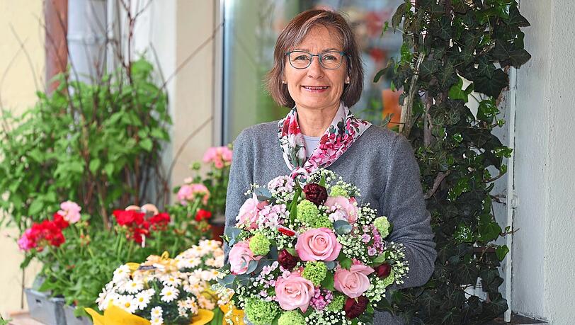 Sabine Löwenstein vor ihrem Blumengeschäft "Blütenzauber" am Partnachplatz. Im Strauß: rosa Rosen, Bartnelken, Schneeball, Eukalyptus, lindgrünes Schleierkraut.