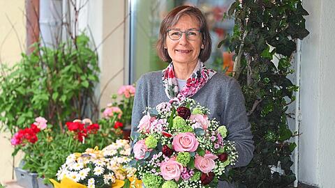 Sabine Löwenstein vor ihrem Blumengeschäft "Blütenzauber" am Partnachplatz. Im Strauß: rosa Rosen, Bartnelken, Schneeball, Eukalyptus, lindgrünes Schleierkraut.